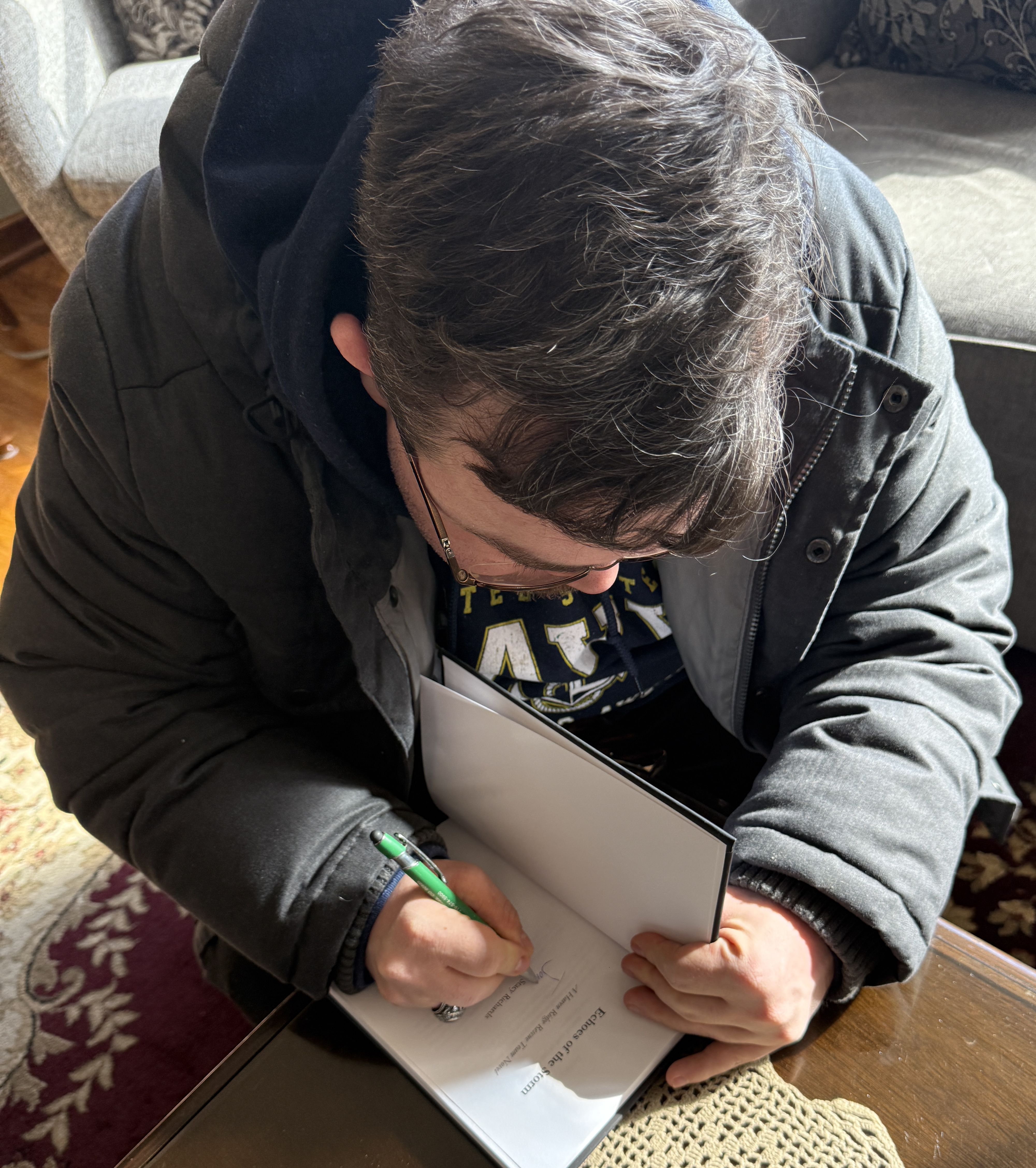 Stacy Richards signing a copy of Echoes of the Storm for a reader